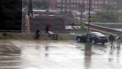 Evanston Detective Ken Carter, seen in black on the left, helps save a suicidal man from jumping off the top of a parking garage. Evanston Detective Ken Carter, seen in black on the left, helps save a suicidal man from jumping off the top of a parking garage.