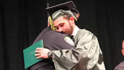 A photo showing Orange Lt. Eric Ellison and Kazzie Portie embracing at his high school graduation has gone viral. A photo showing Orange Lt. Eric Ellison and Kazzie Portie embracing at his high school graduation has gone viral.