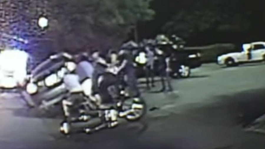 Dallas police officers, firefighters and bystanders worked together to save a woman trapped under a car following a crash earlier this month.