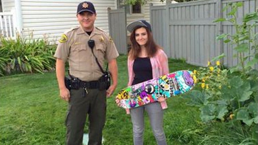 Utah County Deputy John Thomas, left, stands with Kaylie English and her new skateboard.