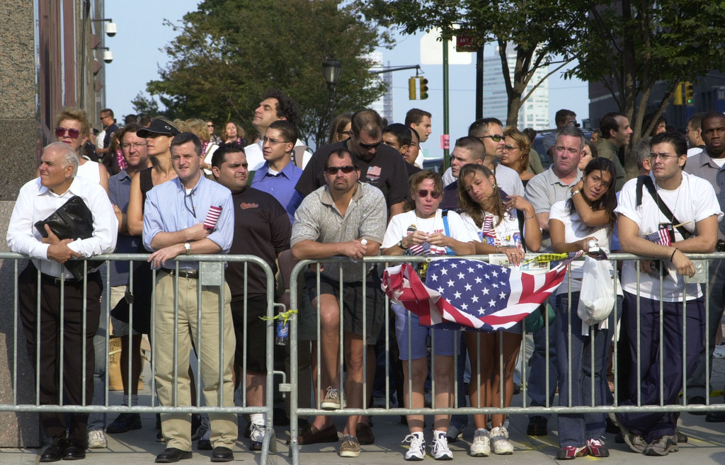 People are seen standing near Ground Zero in New York City on Sept. 11, 2002 to honor the victims lost one year earlier in the 9/11 terrorist attacks.