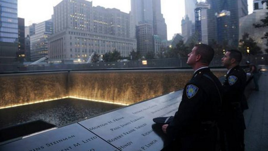 Two Port Authority police officers look on at a reflecting pool at the National September 11 Memorial & Museum in New York City.