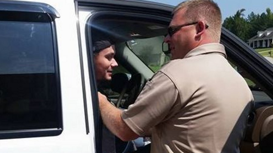 Lauderdale County Sheriff's Deputy Jason Brown helps Deputy Austin Hill from a vehicle after returning from a Huntsville Hospital on Wednesday.