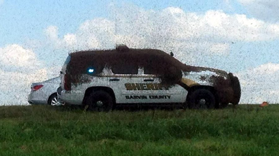 Garvin County Sheriff's Deputy Carl Zink found himself trapped inside his cruiser Tuesday after it became covered by a swarm of bees.