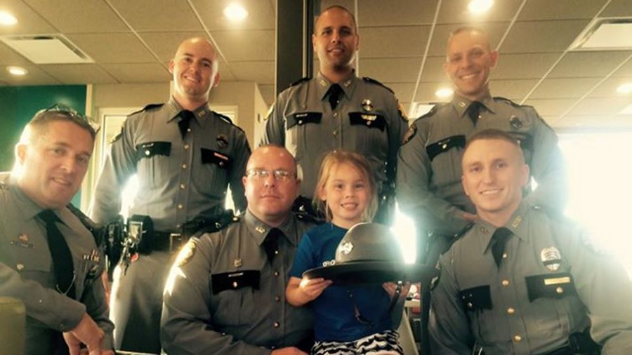 A picture of a little girl posing with law enforcement officers following the funeral for a slain Kentucky State Police Trooper Joseph Cameron Ponder has gone viral.