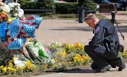 A DFW Airport police officer kneels at the growing memorial at the Euless Police Headquarters on March 2 in Euliss, Texas. A DFW Airport police officer kneels at the growing memorial at the Euless Police Headquarters on March 2 in Euliss, Texas.