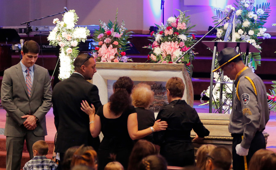 Family members have a moment at the casket at the funeral for detention officer Marianne Johnson on July 22 at the First Baptist Church in Mansfield, Texas.