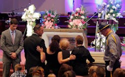 Family members have a moment at the casket at the funeral for detention officer Marianne Johnson on July 22 at the First Baptist Church in Mansfield, Texas. Family members have a moment at the casket at the funeral for detention officer Marianne Johnson on July 22 at the First Baptist Church in Mansfield, Texas.