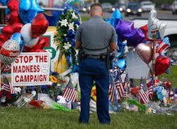 Police officer PJ Freeman stops to pay his respects at the roadside memorial for the three police officers slain in Baton Rouge, La., on July 20.