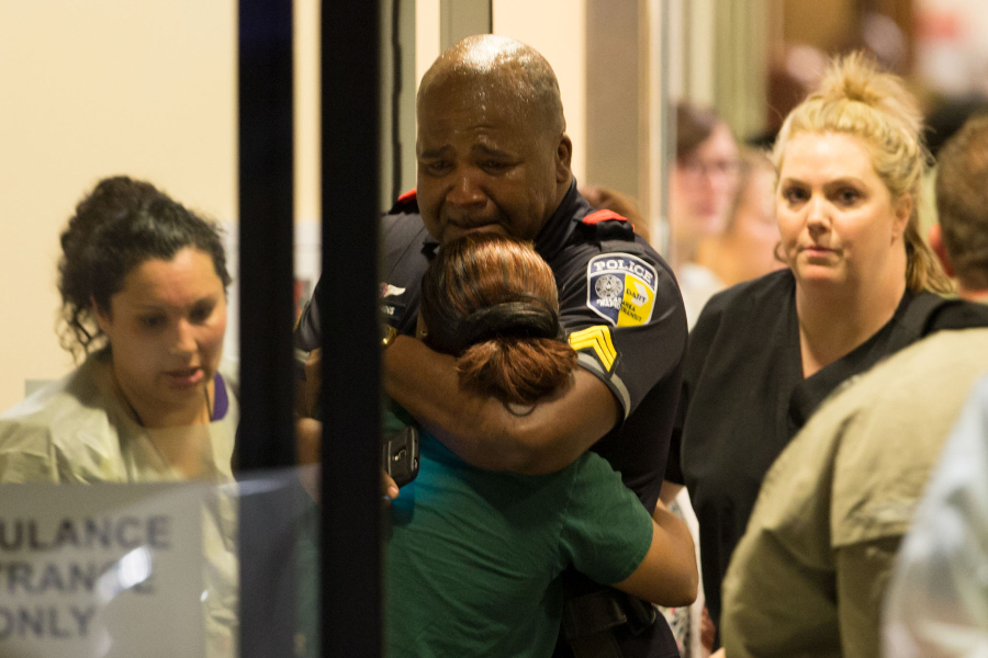 A DART police officer receives comfort at Baylor University Hospital emergency room entrance on July 7.