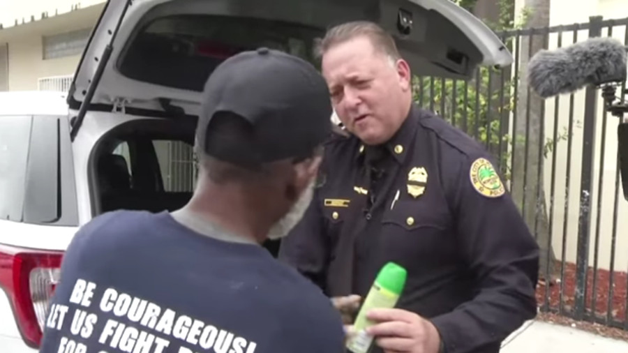 Raw: Miami Police Hand Out Bug Spray to Homeless | Officer