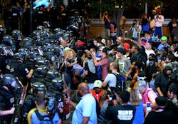 Charlotte police officers begin to move rioters down a street in Charlotte, N.C., on Sept. 21. Charlotte police officers begin to move rioters down a street in Charlotte, N.C., on Sept. 21.