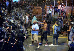 Debris fall upon Charlotte officers and protestors as officers began to push protestors from the intersection near the Epicentre on Sept. 21 in Charlotte, N.C. Debris fall upon Charlotte officers and protestors as officers began to push protestors from the intersection near the Epicentre on Sept. 21 in Charlotte, N.C.