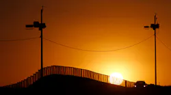 Sunset at the U.S.-Mexico border in Naco, Ariz., where a Border Patrol agent in his car keeps an eye on activity.