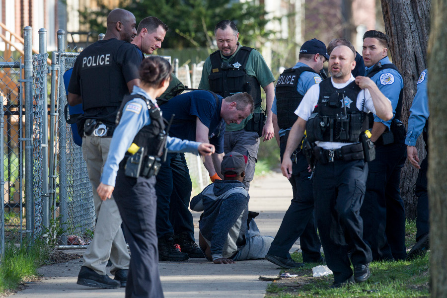 Members of the Chicago Police Department and Chicago Fire Department help a man who was shot on the 7200 block of South Green Street on April 16.