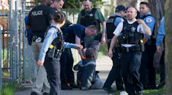 Members of the Chicago Police Department and Chicago Fire Department help a man who was shot on the 7200 block of South Green Street on April 16.