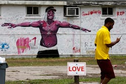 A pedestrian walks past a mural and a memorial wall for Alton Sterling in Baton Rouge, La., on July 18, 2016. The Department of Justice, declining comment, will not bring federal civil rights charges against two police officers involved in Sterling's death. A pedestrian walks past a mural and a memorial wall for Alton Sterling in Baton Rouge, La., on July 18, 2016. The Department of Justice, declining comment, will not bring federal civil rights charges against two police officers involved in Sterling's death.