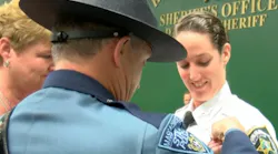 Newly graduated Hillsborough County Sheriff's Deputy Katelyn Kotfila has her badge pinned on by her father, who is a Massachusetts State Police trooper, and her mother.