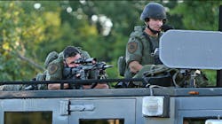 A police sharpshooter keeps an eye on protesters along W. Florissant Avenue on Tuesday, Aug. 12, 2014, in Ferguson, Mo. A police sharpshooter keeps an eye on protesters along W. Florissant Avenue on Tuesday, Aug. 12, 2014, in Ferguson, Mo.