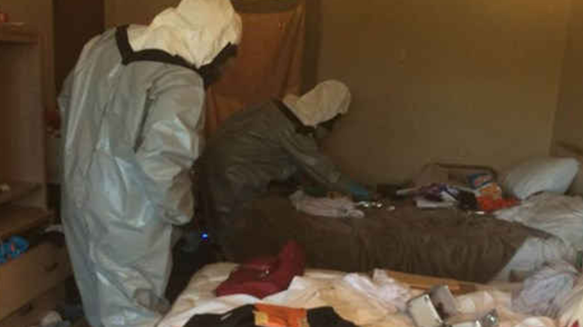 Police officers search a hotel room in Arlington, Wash., August 14, 2017. Three officers had to go to the hospital after a violent reaction to heroin smoke.