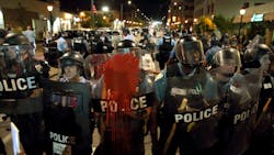 Police officers line up with shields along Delmar Boulevard in University City on Saturday, Sept. 16, 2017.