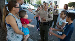 Los Angeles County Sheriff's Deputy Marino Gonzalez, center, talks with community members during a block meeting in Cudahy, Calif., on June 27, 2017.