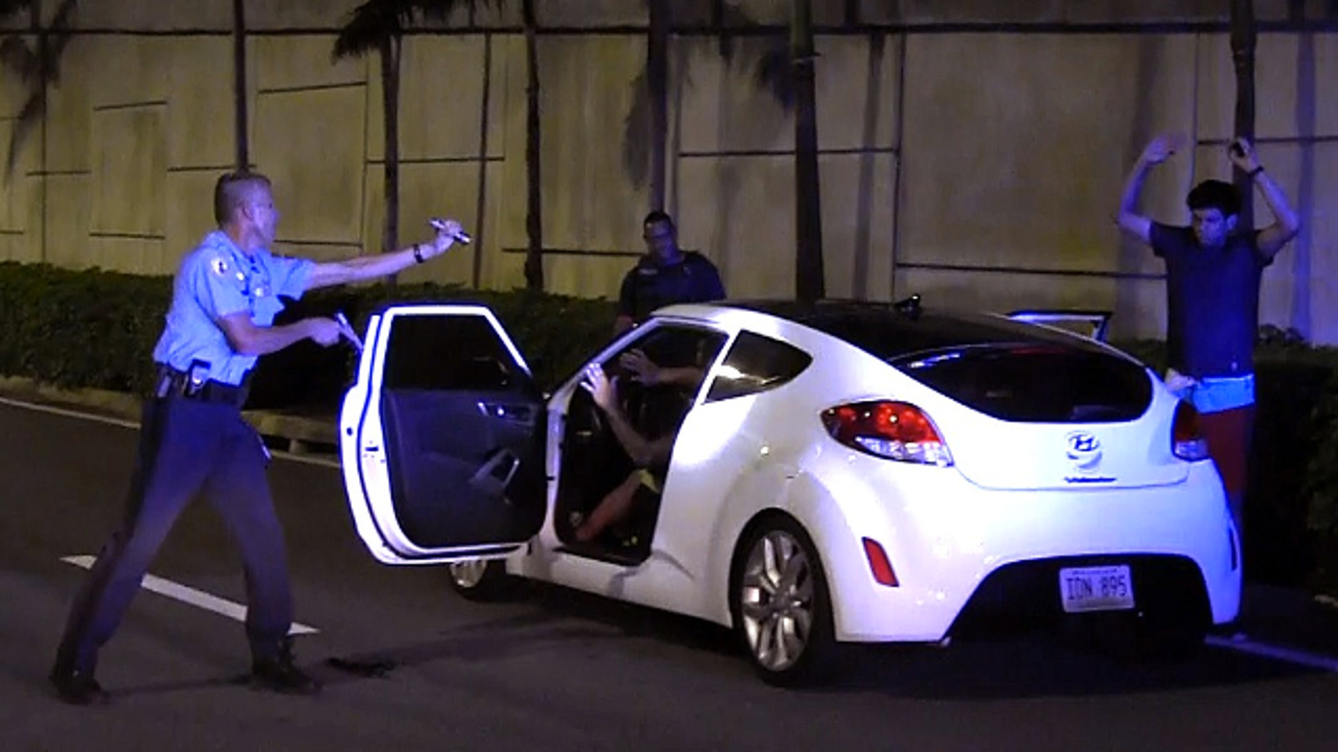 Puerto Rico Police Officer Heriberto Soto shouts commands to the passengers and driver after a late-night high speed chase through San Juan on Wednesday, Oct. 18, 2017.