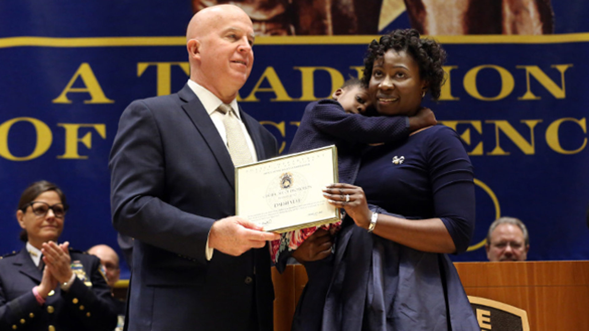 NYPD Officer Dalsh Veve's wife Ester and 2-year-old daughter Dashi accept his promotion to detective.