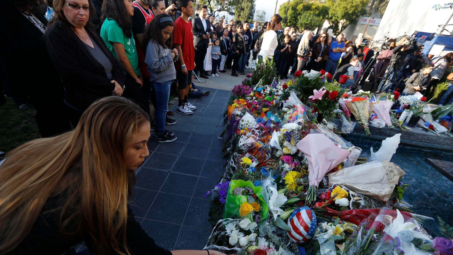 A woman leaves flowersl for fallen Pomona Police Officer Greggory Casillas at the Pomona Police Department Sunday evening in Pomona on March 11, 2018.