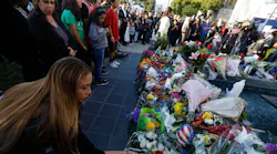 A woman leaves flowersl for fallen Pomona Police Officer Greggory Casillas at the Pomona Police Department Sunday evening in Pomona on March 11, 2018.