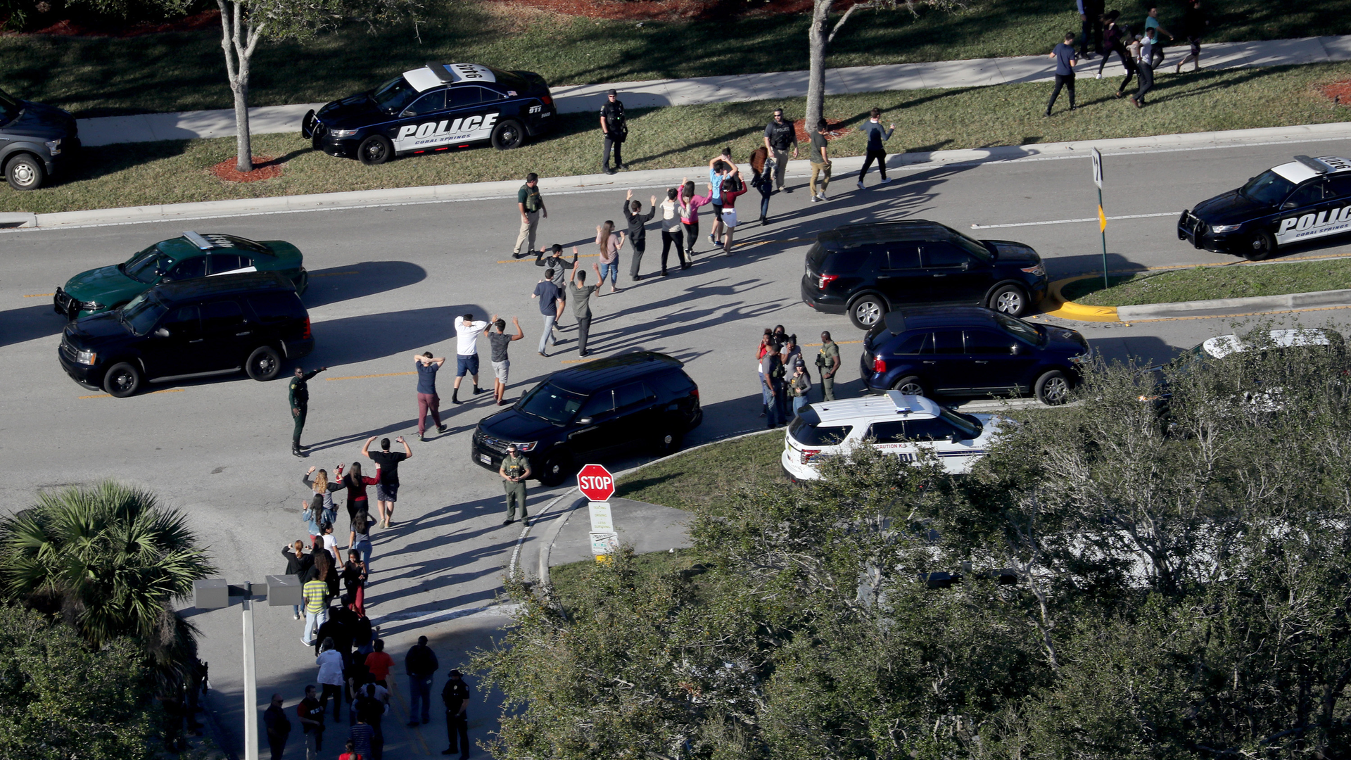 Students are evacuated by police out of Stoneman Douglas High School in Parkland, Fla., after a shooting on Wednesday, Feb. 14, 2018.