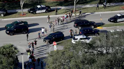 Students are evacuated by police out of Stoneman Douglas High School in Parkland, Fla., after a shooting on Wednesday, Feb. 14, 2018.