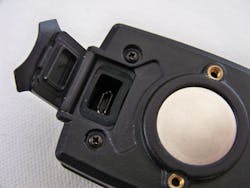 The micro-USB port is safe and secure under a watertight clasp. The sockets above and below the magnet are for a pair screws to attach the shirt clip. The micro-USB port is safe and secure under a watertight clasp. The sockets above and below the magnet are for a pair screws to attach the shirt clip.