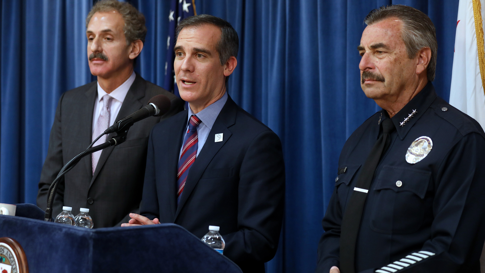 Los Angeles Mayor Eric Garcetti, center, flanked by Los Angeles City Attorney Mike Feuer, left, and LAPD Chief Charlie Beck, during a press conference detailing a court ruling against the Trump administration regarding its efforts to withhold federal grants from jurisdictions over their immigration enforcement policies on Thursday, April 12, 2018 at City Hall in Los Angeles, Calif.