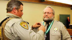 Park County Sheriff's Deputy Brian Elliott-Pearson is seen receiving a Meritorious Service medal for saving a life in 2015.