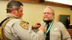 Park County Sheriff&apos;s Deputy Brian Elliott-Pearson is seen receiving a Meritorious Service medal for saving a life in 2015.