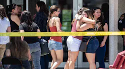 Family members hug to each other outside the family reunification center at MacArthur Elementary-Intermediate School following a mass shooting in El Paso, Texas on Sunday, August 4, 2019.