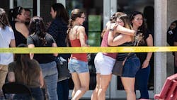 Family members hug to each other outside the family reunification center at MacArthur Elementary-Intermediate School following a mass shooting in El Paso, Texas on Sunday, August 4, 2019.