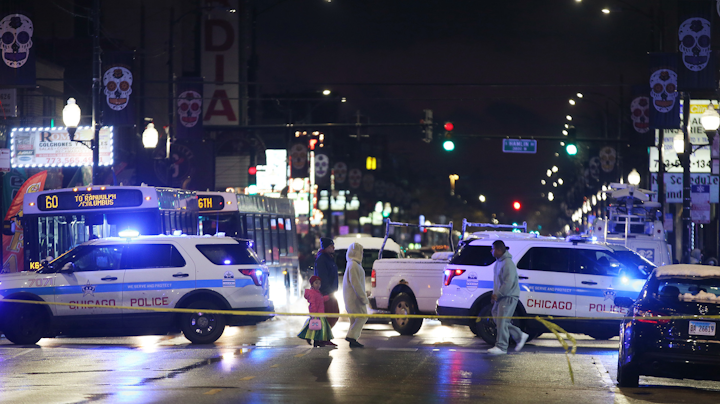 Trick-or-treaters walk past a crime scene in the 3700 block of West 26th Street in Chicago, where a 7-year-old girl was shot while trick-or-treating on Thursday, Oct. 31, 2019. The girl, dressed as a ladybug, was taken the hospital in critical condition with a chest wound.
