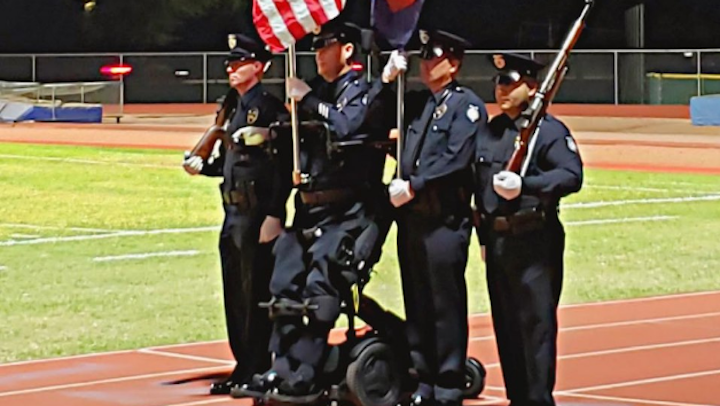 Peoria Police Officer William Weigt, who was paralyzed in the line of duty 14 years ago, was able to stand once again for the national anthem thanks to the help of a special wheelchair.