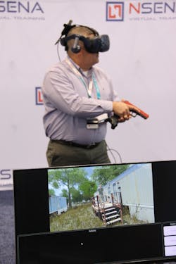 One attendee trying out NSENSA&apos;s VR training system. The firearm controller was specially designed for the system. A tracking sensor sticks out from where the magazine would be.