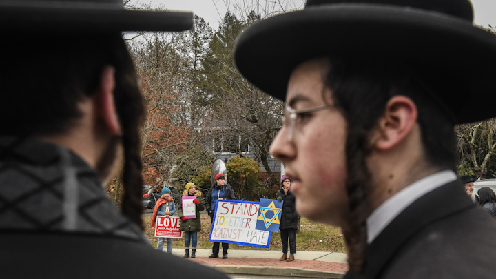 People hold signs of support near the house of Rabbi Chaim Rottenberg on December 29, 2019 in Monsey, New York. Five people were injured in a knife attack during a Hanukkah party and a suspect, identified as Grafton E. Thomas, was later arrested in Harlem.