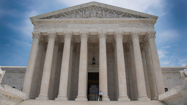 A police officer stands guard on the steps of the US Supreme Court in Washington, DC, June 15, 2017.