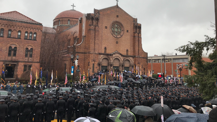 A sea of officers stand at attention as the casket holding Detective Joseph Seals is brough into St. Aedan's church in Jersey City.