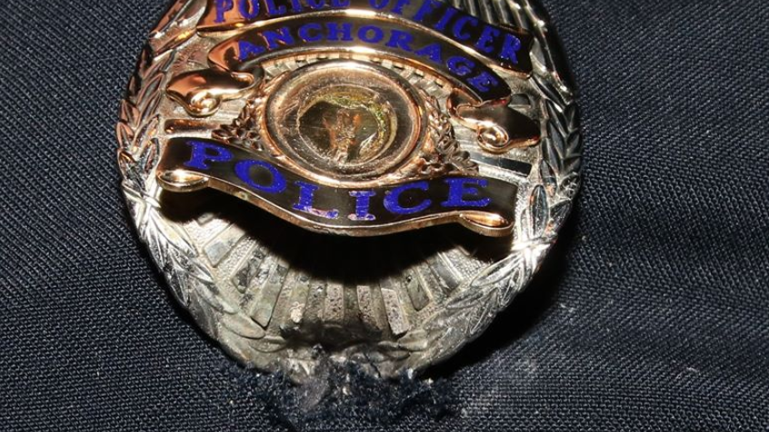 A bullet struck an Anchorage police officer&rsquo;s badge and then deflected into his body armor.