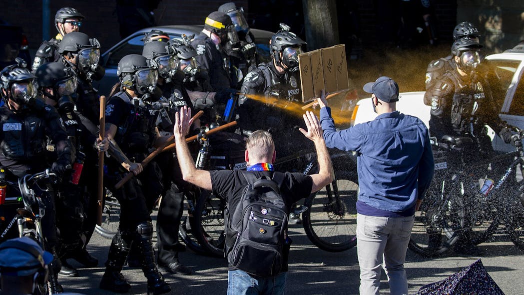 Seattle Police use pepper spray on protesters along Harvard Avenue behind Seattle Central College as they advance their line during a &apos;Youth Day of Action and Solidarity with Portland&apos; on Saturday, July 25, 2020.
