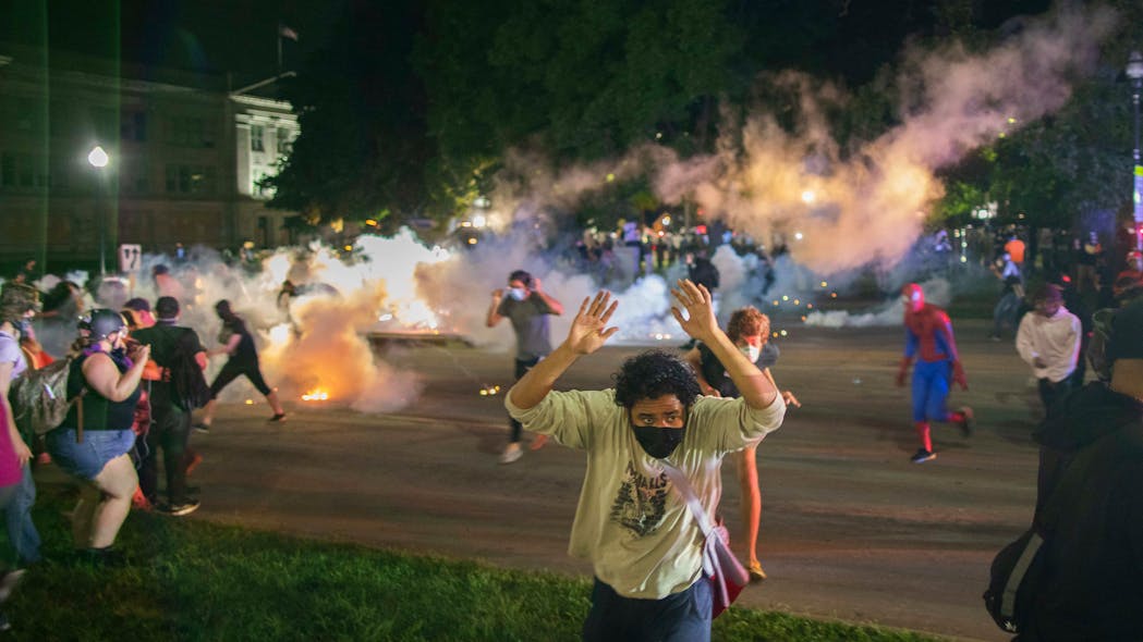 Tear gas lands around protesters after they refused to listen to police demands to disperse near the courthouse in Kenosha, Wisconsin on Tuesday, August 25, 2020.