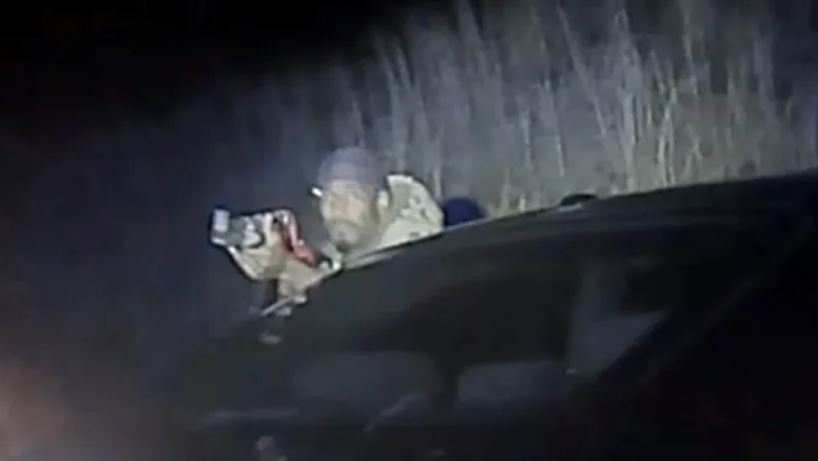 In a still from video taken by a state trooper's camera, Timothy Carruth fires an AK-47 at the trooper after a chase ended with Carruth wrecking his car.
