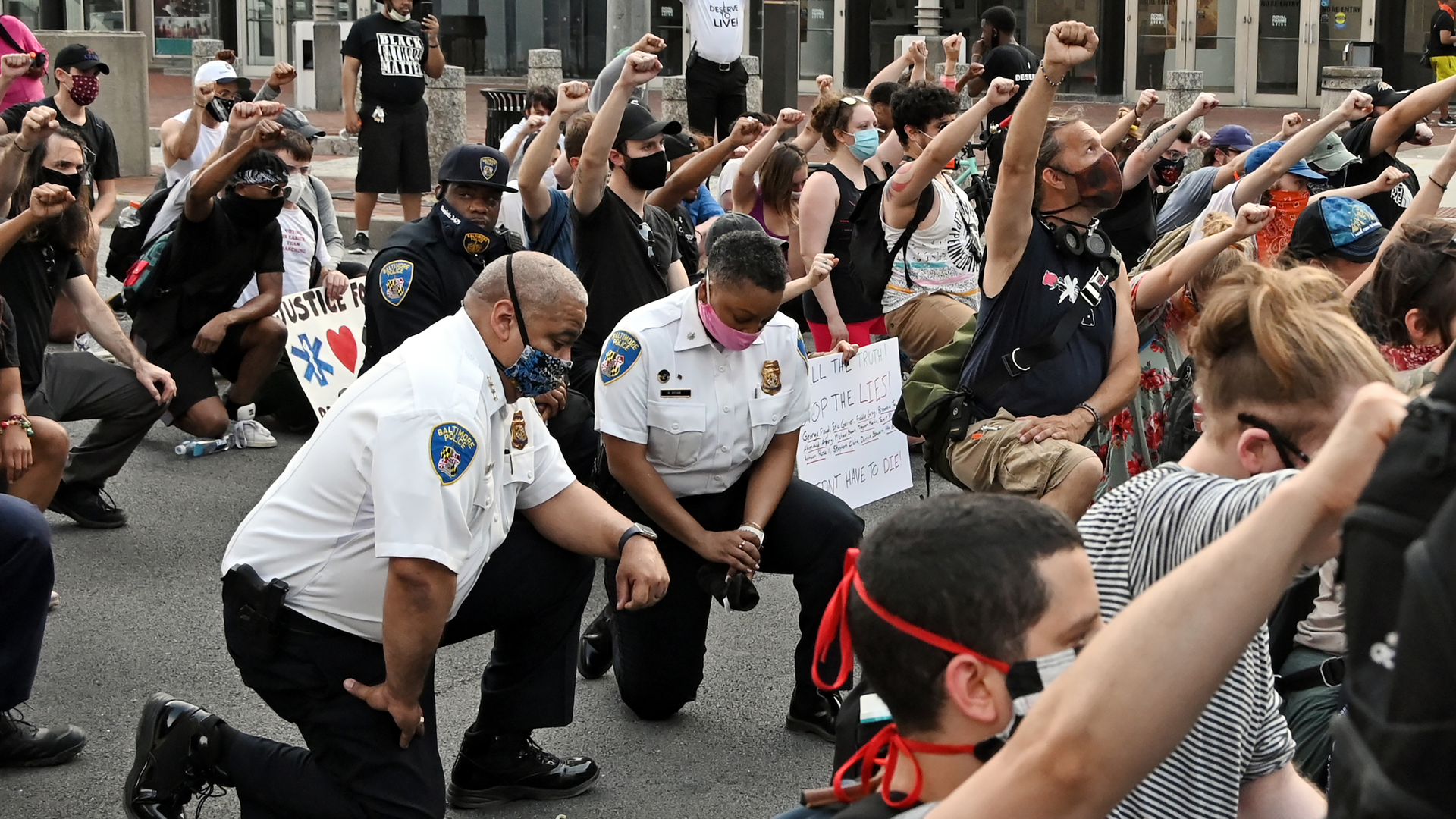 Baltimore City Police Commissioner Michael Harrison takes a knee with protestors on Hopkins Plaza on June 4, 2020.