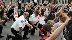 Baltimore City Police Commissioner Michael Harrison takes a knee with protestors on Hopkins Plaza on June 4, 2020.
